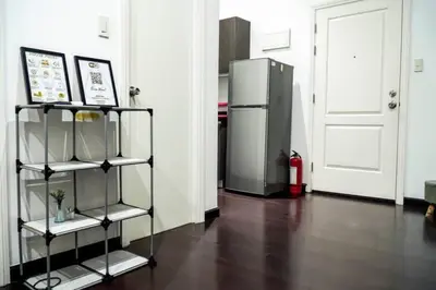 a room with a refrigerator and a shelf in front of a door at 66F 1 BR Penthouse with 2 Balconies Panoramic View in Manila