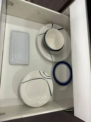 four plates and bowls on a shelf in a drawer at Gramercy Studio with City View fast WIFI Free use of Amenities in Manila