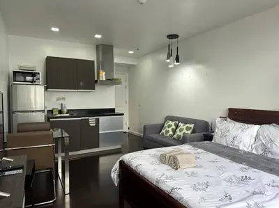 a bedroom with a bed and a kitchen with a couch at Gramercy Studio with City View fast WIFI Free use of Amenities in Manila