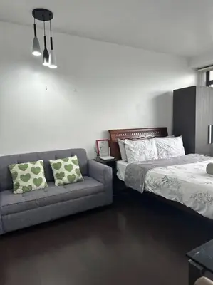 a bedroom with a couch and a bed and a couch at Gramercy Studio with City View fast WIFI Free use of Amenities in Manila