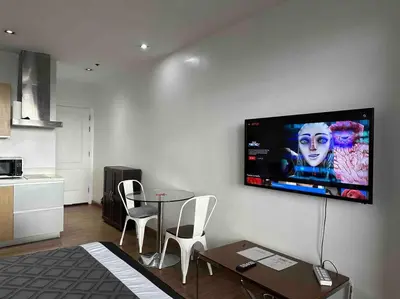 a living room with a flat screen tv on a wall at 52F Sunset View Studio in Gramercy Pool Gym Sauna in Manila