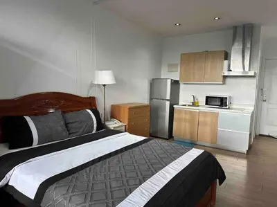 a bedroom with a large bed and a kitchen at 52F Sunset View Studio in Gramercy Pool Gym Sauna in Manila