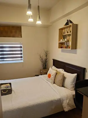 a bedroom with a bed with white sheets and pillows at Tessa's Place Staycation 4FI in Jalang