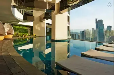 a swimming pool with a view of a city skyline at Spacious Corner 1 Bedroom with Balcony Gramercy in Manila