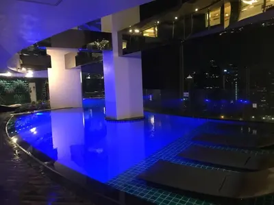 a swimming pool with blue lights in a building at Spacious Corner 1 Bedroom with Balcony Gramercy in Manila