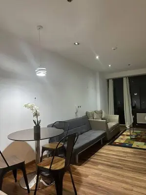 a living room with a couch and a table at Spacious Corner 1 Bedroom with Balcony Gramercy in Manila
