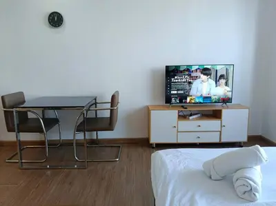 a bedroom with a table and a tv and a bed at 58F Minimalist Studio Panoramic View in Gramercy in Manila