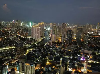 a view of a city at night with lights at 58F Minimalist Studio Panoramic View in Gramercy in Manila