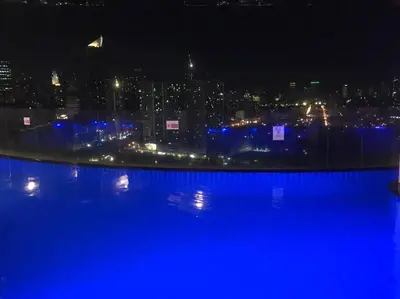 a view of a city at night with blue lights at 58F Minimalist Studio Panoramic View in Gramercy in Manila