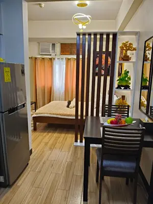 a kitchen and dining room with a table and a bed at Tessa's Place Staycation 10FI in Jalang