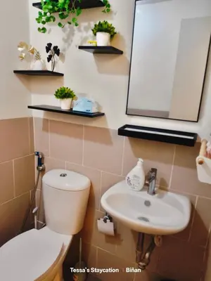 a bathroom with a toilet and a sink and a mirror at Tessa's Place Staycation 10FI in Jalang