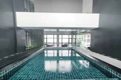 a large swimming pool in a building with a large ceiling at 64F Spacious 1 BR Nice View Pool Sauna Gym in Manila