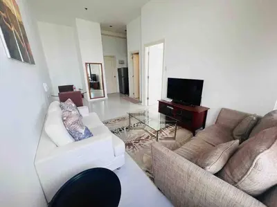 a living room with two couches and a television at 64F Spacious 1 BR Nice View Pool Sauna Gym in Manila