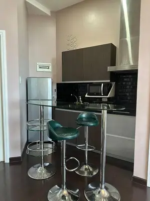 a kitchen with two green bar stools and a counter at 68F 1 Bedroom Penthouse Suite Gramercy Pool Sauna in Manila