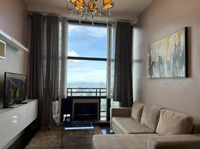 a living room with a couch and a large window at 68F 1 Bedroom Penthouse Suite Gramercy Pool Sauna in Manila