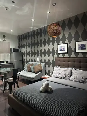 a bedroom with a bed and a living room at Penthouse Studio Highspeed Wi Fi Smart TV Pool GYM in Manila