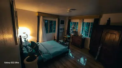 a bedroom with a bed and a lamp and windows at Elegant Villa in Manila