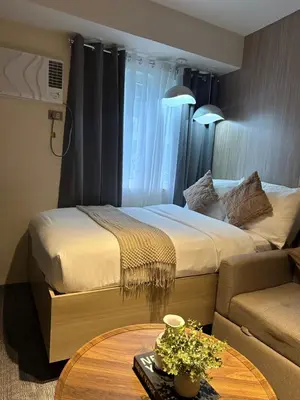 a hotel room with a bed and a table and a couch at El Suite in Puting Kahoy