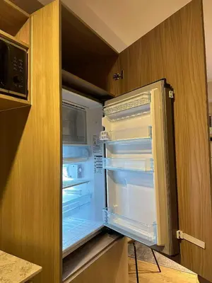 an empty refrigerator with its door open in a kitchen at El Suite in Puting Kahoy
