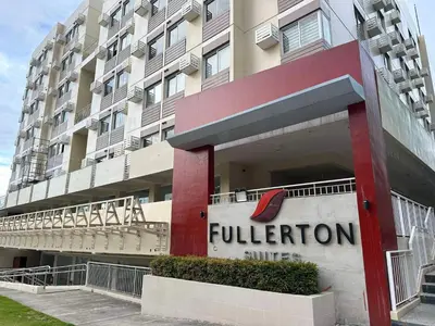 a building with a sign for a hotel at El Suite in Puting Kahoy
