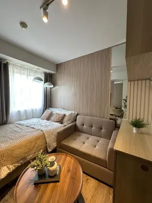 a bedroom with a bed and a couch and a table at El Suite in Puting Kahoy