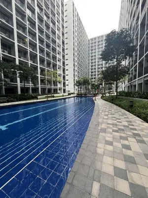 a swimming pool in a city with tall buildings at Straightforward 1 BR Shore 2 Residences near MOA NAIA PICC in Manila