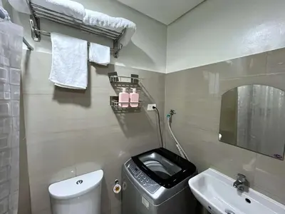 a bathroom with a toilet and a sink and a mirror at Straightforward 1 BR Shore 2 Residences near MOA NAIA PICC in Manila
