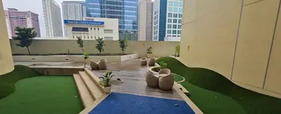 a patio in a building with plants and buildings at Makati Bliss Apartment - Cozy Urban Retreat in Manila