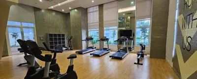 a gym with treadmills and elliptical machines at Makati Bliss Apartment - Cozy Urban Retreat in Manila