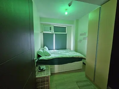 a small room with a small bed with a window at Makati Bliss Apartment - Cozy Urban Retreat in Manila