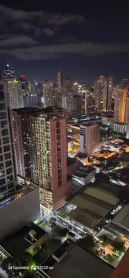 a view of a city at night with buildings at Makati Bliss Apartment - Cozy Urban Retreat in Manila