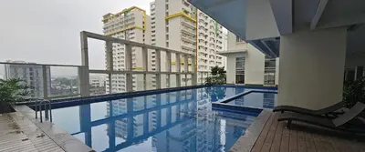 a swimming pool with a view of some buildings at Makati Bliss Apartment - Cozy Urban Retreat in Manila
