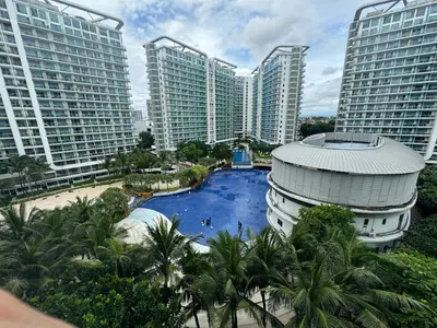 a pool in the middle of a city with tall buildings at Azure Apartment in Manila