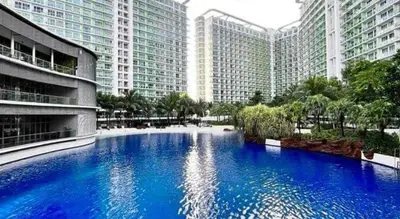 a large blue pool in front of tall buildings at Azure Apartment in Manila