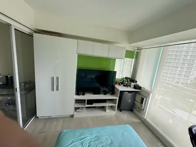 a living room with a flat screen tv in a room at Azure Apartment in Manila