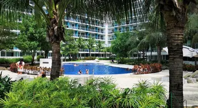 a swimming pool in front of a large building at Azure Apartment in Manila