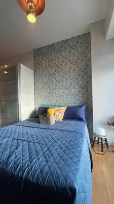 a bed with a blue comforter in a bedroom at 8Adriatico Penthouse Studio Unit! Walk Away to US Embassy and St Lukes Ermita in Manila