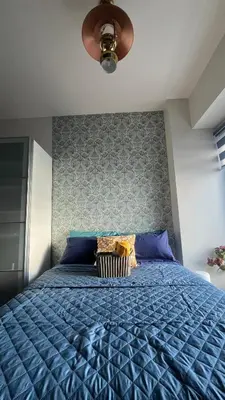 a bedroom with a blue bed with a ceiling fan at 8Adriatico Penthouse Studio Unit! Walk Away to US Embassy and St Lukes Ermita in Manila