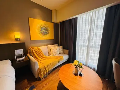 a hotel room with a bed and a table at Novotel Residences ACQUA near Rockwell Makati in Manila