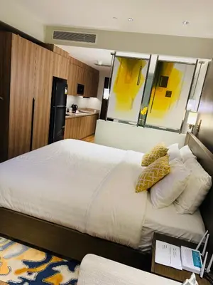 a bedroom with a large bed with a large mirror at Novotel Residences ACQUA near Rockwell Makati in Manila