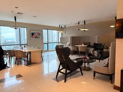 a living room with chairs and tables in a building at Novotel Residences ACQUA near Rockwell Makati in Manila