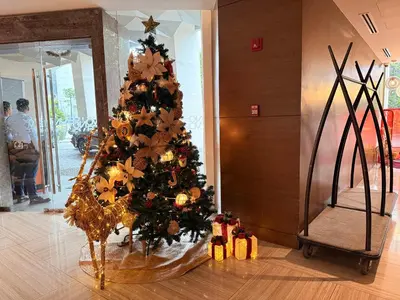 a christmas tree in a living room with lights at Novotel Residences ACQUA near Rockwell Makati in Manila