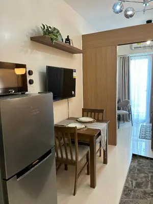 a kitchen and dining room with a table and a refrigerator at Cozy Space in Makati - Margareth Suite in Manila