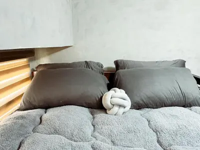 a teddy bear sitting on top of a bed at Urban Hive 1821 in Manila