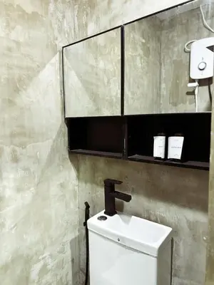 a bathroom with a sink and a mirror above a toilet at Urban Hive 1821 in Manila