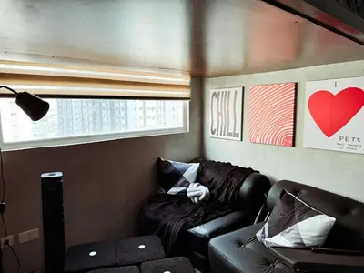 a living room with a leather couch and a heart picture at Urban Hive 1821 in Manila