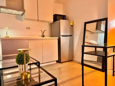 a kitchen with a glass table and a refrigerator at Azure Playfull Living 1 bedroom in Manila