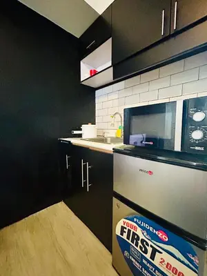 a kitchen with a box of first edition first aid at Cozy Studio Unit Near MRT Shaw & Malls in Manila