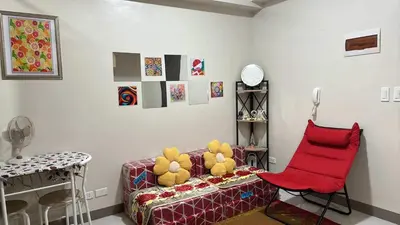 a living room with a couch and a red chair at Solana Tower 1 New and Very Neat Studio Unit near SM Manila in Manila