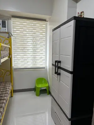 a bedroom with a door and a green stool at Solana Tower 1 New and Very Neat Studio Unit near SM Manila in Manila